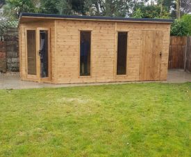 Wooden garden room with tall windows and side storage section, set on paving with lawn and trees in the background